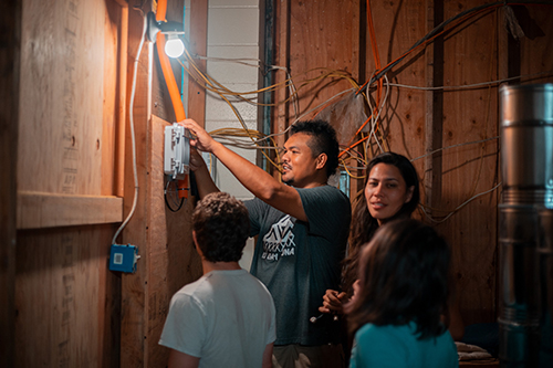 Brandon Makaʻawaʻawa, Mariel Triggs from MuralNET, Spencer Sevilla, and others work on installing the community network in Pu‘uhonua o Waimānalo